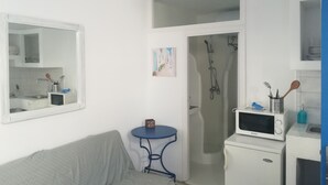 A compact kitchen with a microwave, sink, and a small table. - Gorgeous Mykonian Studio DT Ornos (Mykonos)