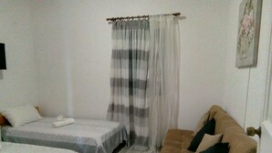 A room with two single beds, a sofa, and a curtain. - Cycladic Studio - 4People DT Ornos (Mykonos)
