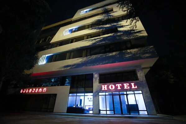 A modern hotel with a prominent "HOTEL" sign, large windows, and a multi-story structure. - West Tower Hotel (Kutaisi)