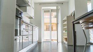 Eine moderne Küche mit einer Schiebeglastür, die auf einen Balkon führt.