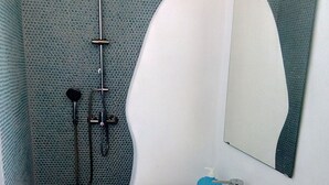 A bathroom with a shower, a sink, and a mirror.