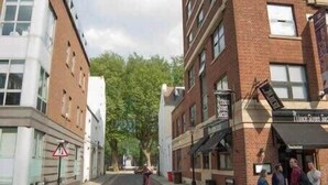 Una calle con edificios, un paso de peatones y un letrero que indica zona escolar.