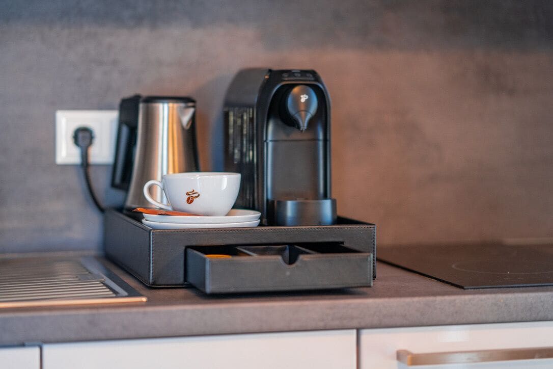 Eine Kaffeemaschine mit Tasse und Untertasse auf einer Arbeitsplatte.