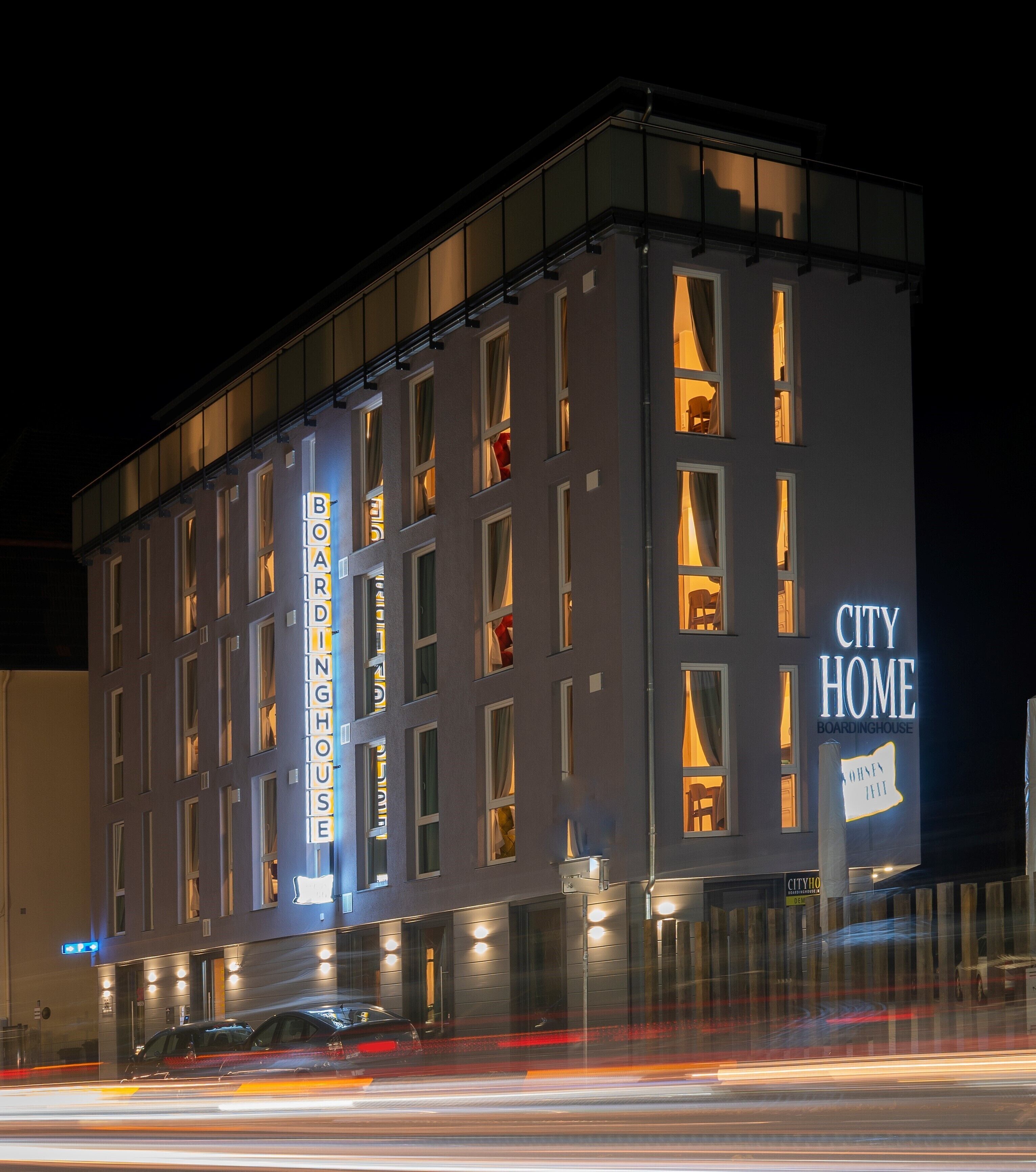 A modern building with multiple windows, labeled "CITY HOME BOARDINGHOUSE".