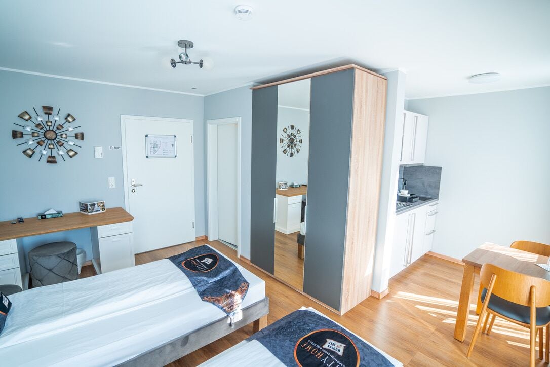 Una habitación de hotel moderna con cama, escritorio y zona de comedor.