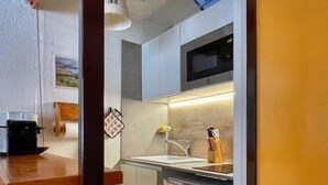 A compact kitchen with a microwave, sink, and a small countertop.