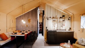 Un intérieur moderne et compact comprenant un coin repas, une cuisine et un espace salon.