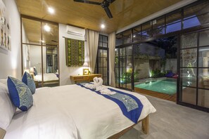 Une chambre spacieuse avec un grand lit, un bureau et une vue sur une piscine extérieure.