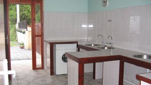 A kitchen with a wooden island, two sinks, and a dishwasher. - Camping L'Arrayade (Ger)