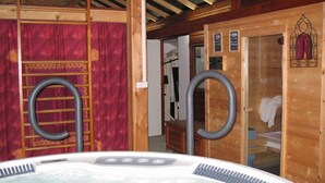 A wooden spa room with a hot tub, a sauna, and a shower area. - Camping L'Arrayade (Ger)