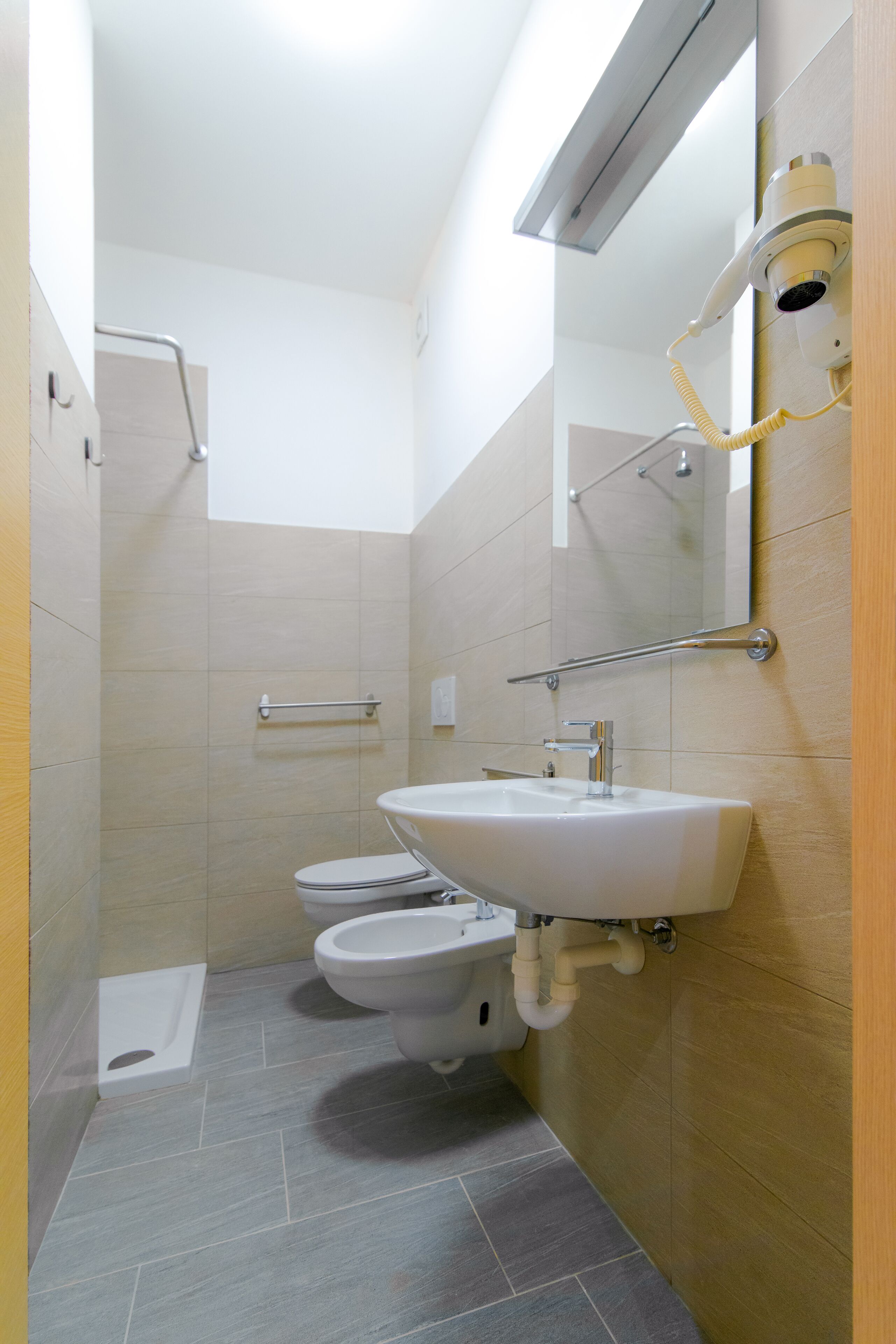 A modern bathroom with a sink, toilet, and bidet.