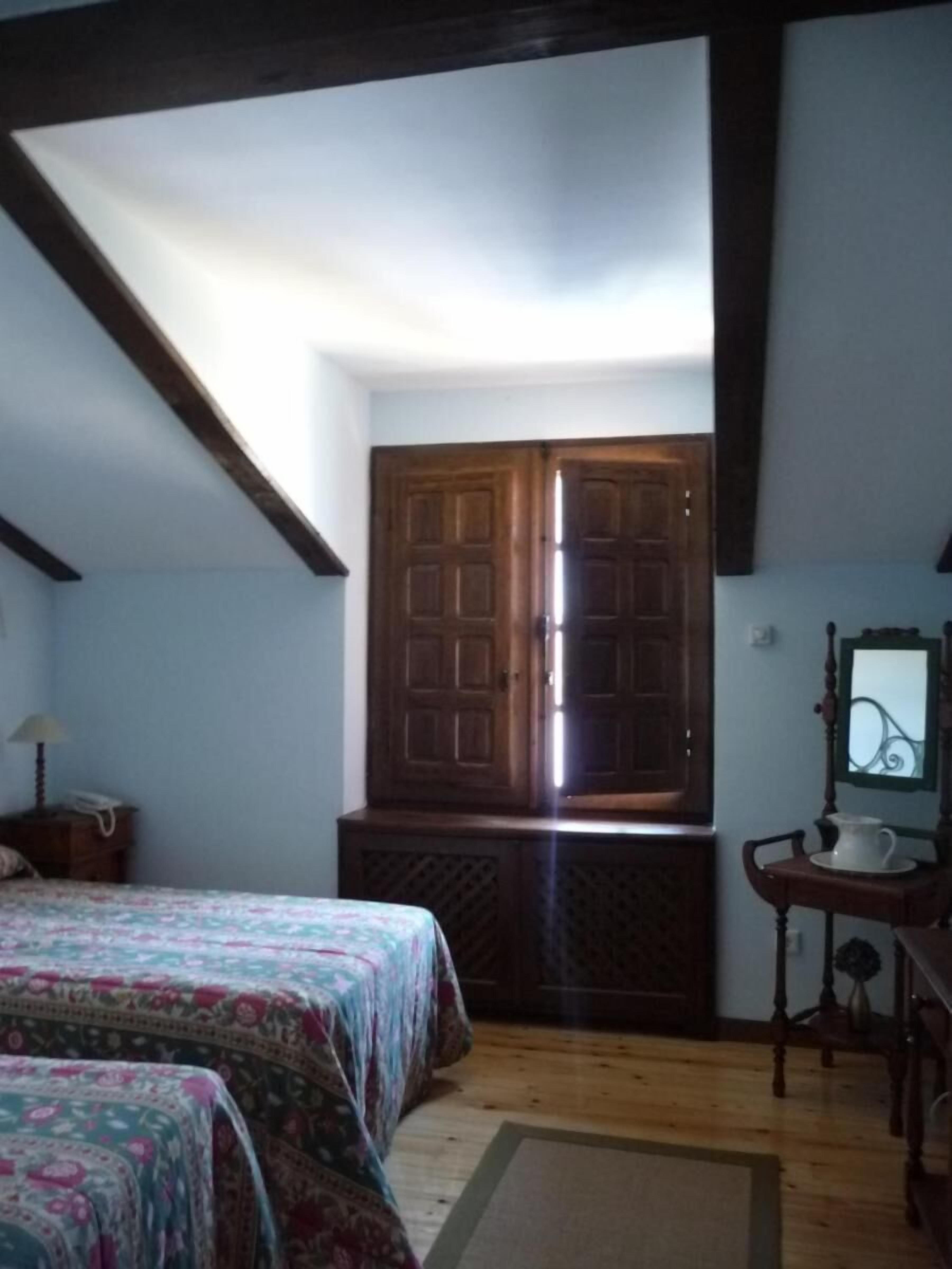 Un dormitorio con dos camas, un armario de madera, un escritorio con una computadora y un espejo.