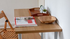 Et træbord med en bog, en træskål og en lille plantepotte.