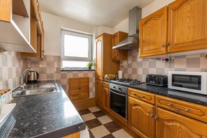 Refrigerador em uma área comum, micro-ondas, fogão, cooktop