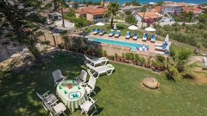 A residential property with a swimming pool, outdoor seating, and a view of the sea. - Vallia's Apartments (Zakynthos)