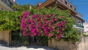 A building with a traditional architectural style, featuring a tiled roof and balconies. - Vallia's Apartments (Zakynthos)