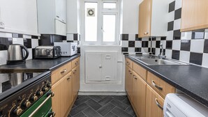 A compact kitchen with a gas stove, a microwave, a toaster, and a sink. - Tower Bridge Accommodation - 5 (London)