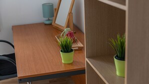 A wooden table with a green potted plant, a wooden picture frame, and a teal lamp. - Tower Bridge Accommodation - 5 (London)
