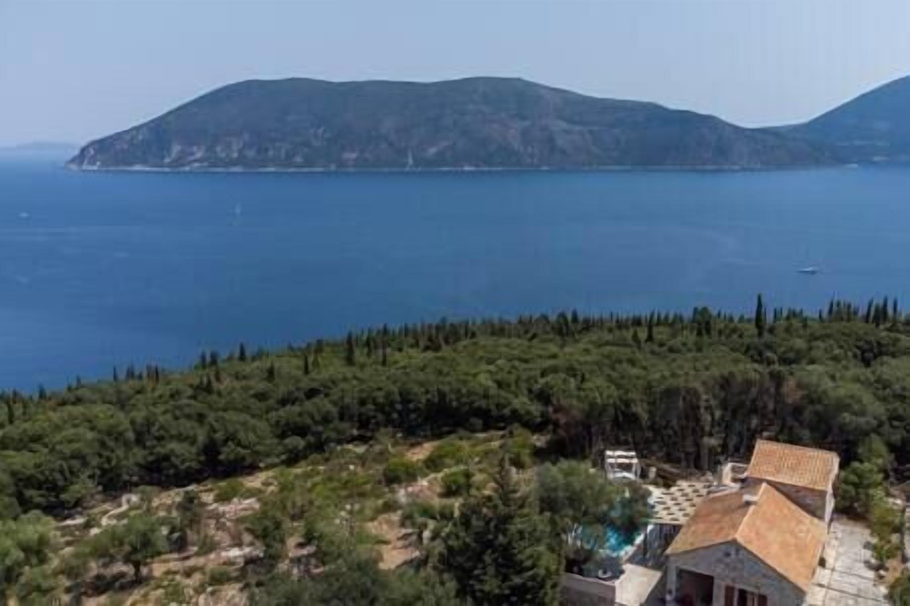Une propriété située sur la côte, offrant une vue sur la mer et sur une chaîne de montagnes lointaine.