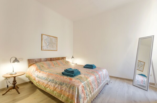 A bedroom with a bed, a round table, a lamp, a mirror, and a map on the wall. - La Romantica at the Colosseum, holidays apartment in the "Ancient Rome". (Roma)
