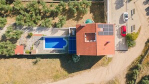 An aerial view of a house with a swimming pool, a red-roofed structure, and a parked car. - Casa Rural Mirador de los Tomillos (Cardena)