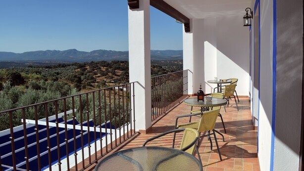 A balcony with a pool, outdoor seating, and a view of mountains. - Casa Rural Mirador de los Tomillos (Cardena)
