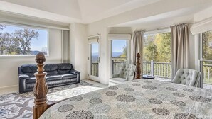 A spacious room with a large bed, a black leather sofa, and a view of the outdoors. - 10 Min TO DT, 16 min to Biltmore, Lg Home,  Apartment Incl., Peaceful & Quiet (Asheville)