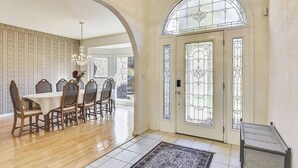 A dining area with a wooden table and chairs, a chandelier, and a patterned wallpaper. - 10 Min TO DT, 16 min to Biltmore, Lg Home,  Apartment Incl., Peaceful & Quiet (Asheville)