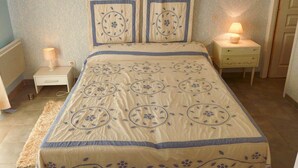 A bedroom with a bed, two bedside tables, a nightstand, a lamp, and a rug. - Nice quiet house classified 3* in Narbonne with private overflowing pool (Narbonne)