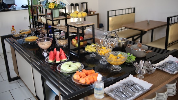 A buffet table with various food items and utensils. - Hotel Iguacu (Dionisio Cerqueira)