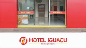 The entrance of Hotel Iguacu with a red facade and a glass door. - Hotel Iguacu (Dionisio Cerqueira)