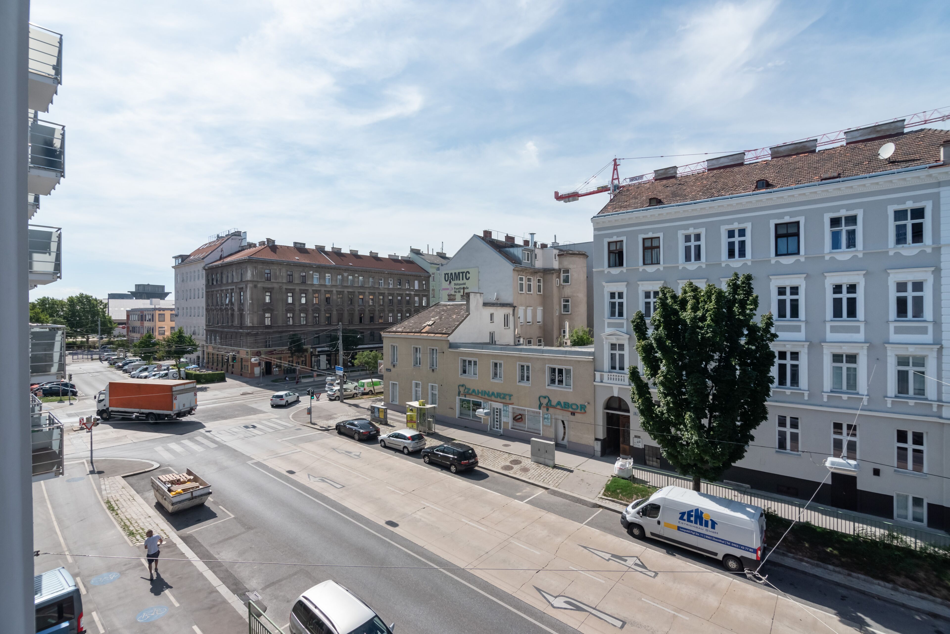 En gatubild med en byggnad där det står ”ZAHNARF Labor” och en parkerad skåpbil.
