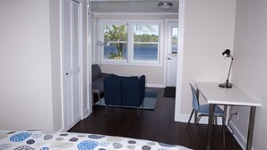 Un dormitorio con cama, escritorio y vistas al exterior.