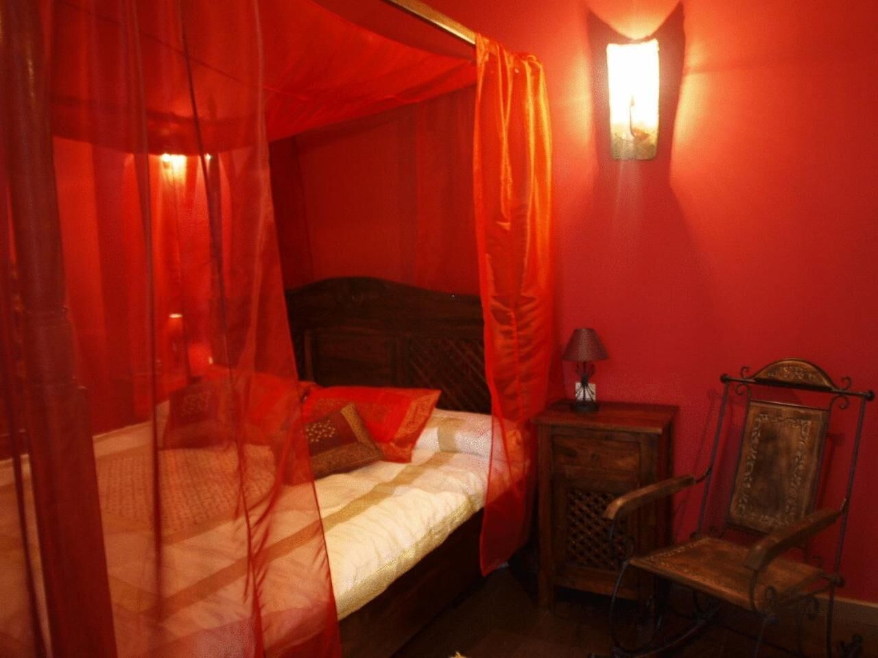 Una habitación con una cama, una mesita de noche y una silla.