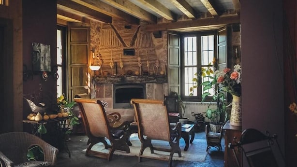 A rustic interior with exposed wooden beams, a stone fireplace, and traditional furniture. - Posada Real El Señorío de la Serrezuela (Aldeanueva De La Serrezuela)