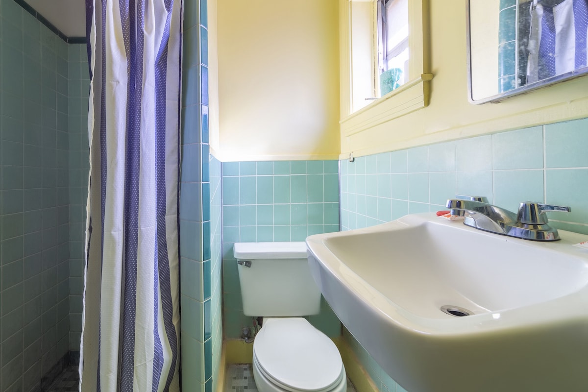 A bathroom with a toilet, sink, and shower curtain.