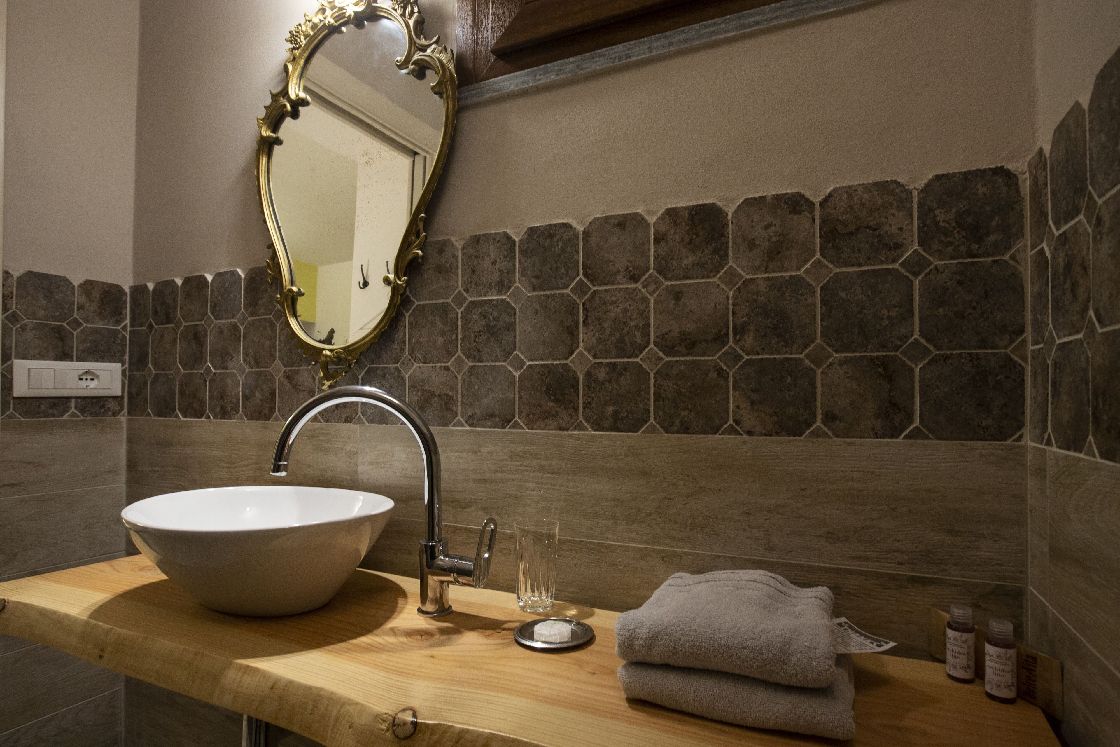 A bathroom with a large oval sink, a mirror, and a towel on the counter.