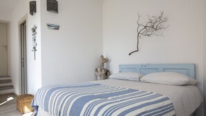 A bedroom with a bed, a wall-mounted branch decoration, and a wicker basket. - Agriturismo LaValleggia (Tovo San Giacomo)