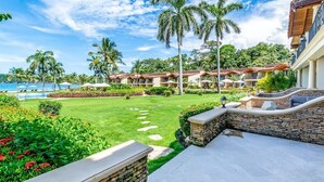 A resort with a pool, palm trees, and a clear sky. - Stylish Split-Level Condo with a Shaded Terrace, Direct Beach Access, and Resort (Playa Flamingo)