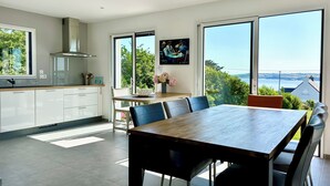 Una cocina moderna con armarios blancos y un ventanal con vistas panorámicas.