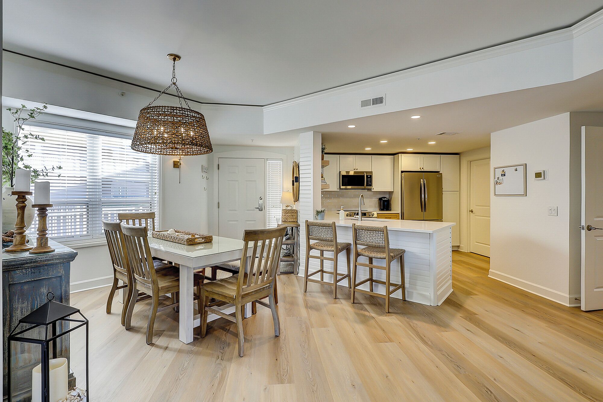 A modern kitchen with white cabinetry, a central island, and stainless steel appliances.