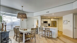 Een moderne keuken met witte kasten, een centraal eiland en roestvrijstalen apparatuur.