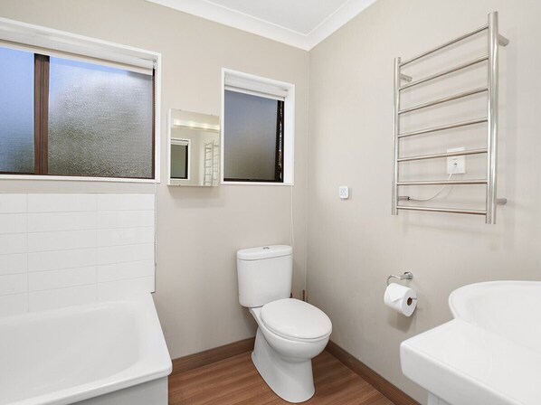 Ein modernes Badezimmer mit Toilette, Badewanne und Waschbecken.