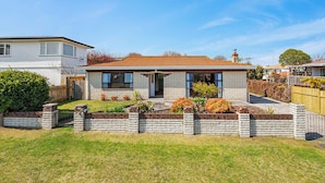 A two-story house with a brick exterior, a front porch, and a well-maintained lawn.