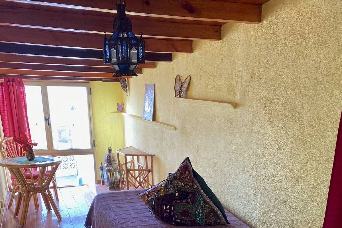 A cozy bedroom with a wooden bed, a small table, and a chair.