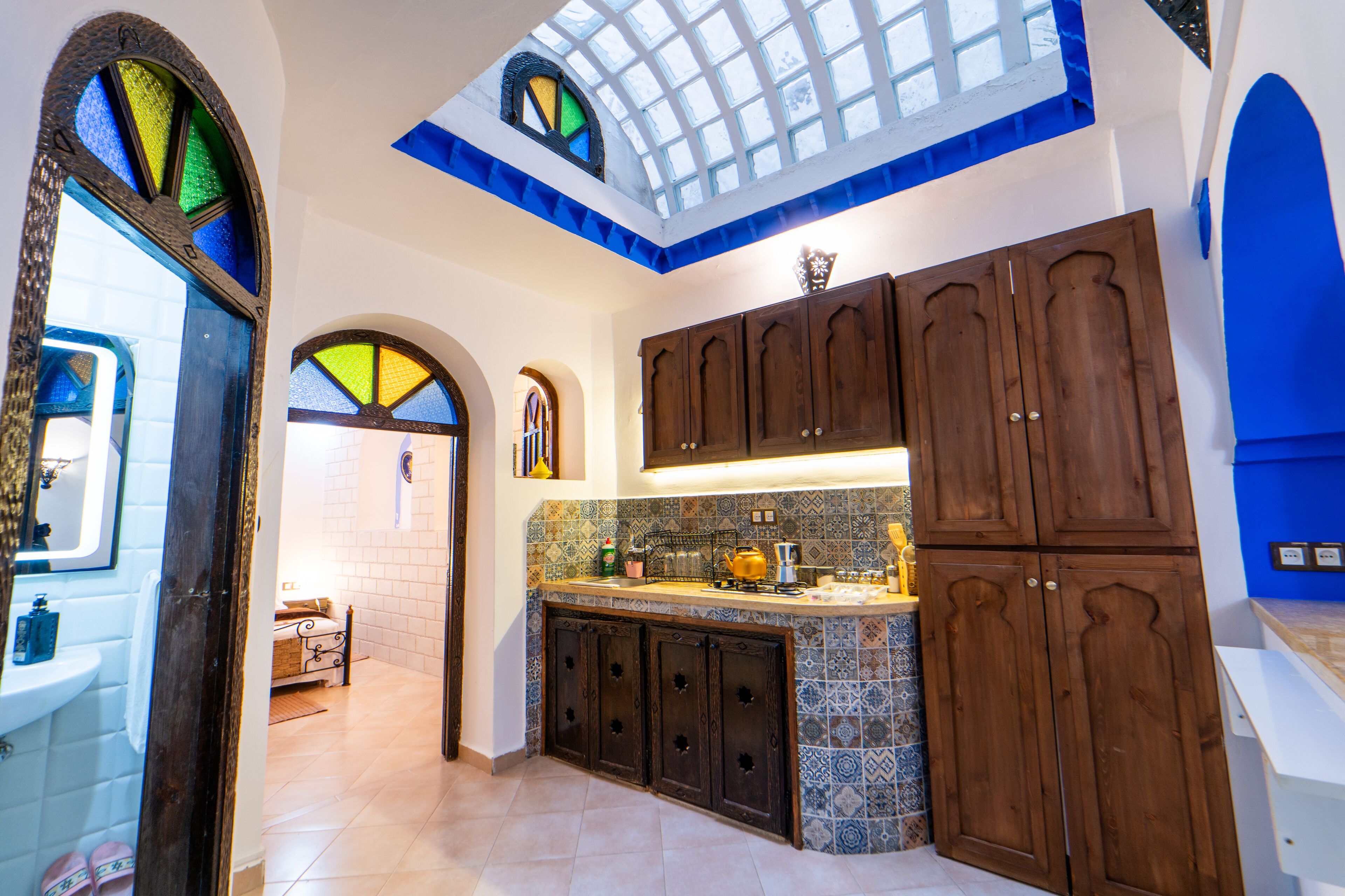 A kitchen with wooden cabinets, a tiled backsplash, and a skylight.