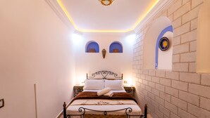 Une chambre à coucher bien rangée, avec un lit, des tables de chevet et un mur décoratif.