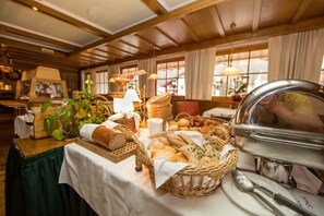 A buffet setup with various breads, pastries, and a buffet station. - Steinbock Apartments (Samnaun)