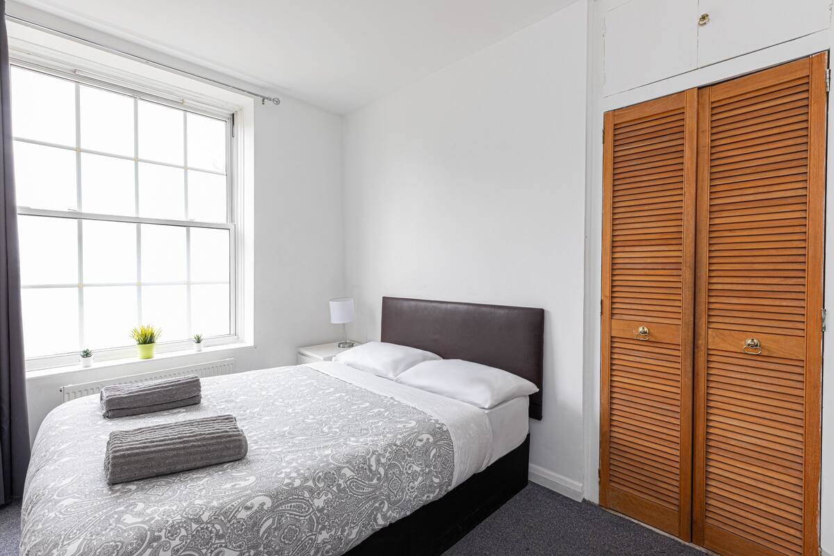 Laptop workspace, iron/ironing board, bed sheets