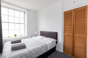 Habitación doble | Espacio para trabajar con laptop y tabla de planchar con plancha